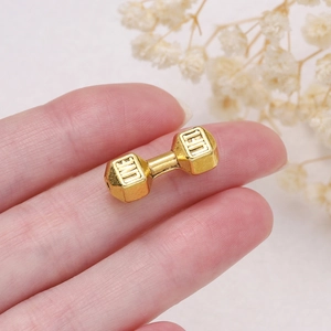 Macro detail of golden dumbbell charm bead with engraved Live Lift text for DIY jewelry