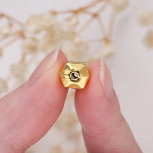 Macro shot of gold-plated hexagonal barbell beads with 1.6mm hole for jewelry making
