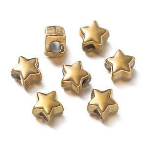 Macro shot of gold star-shaped stainless steel spacer beads with holes for DIY jewelry
