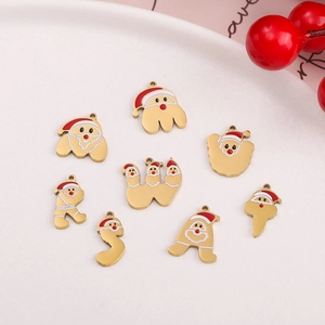 Detailed view of Christmas Santa and initial charms for DIY jewelry in a white tray