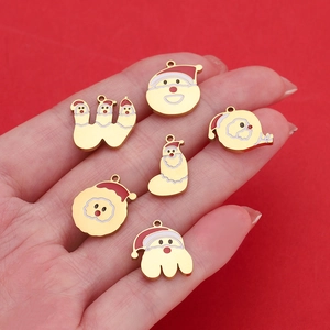 Macro view of small gold-plated stainless steel Santa charms with red enamel details