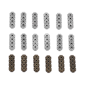 Vue détaillée de perles d'espacement à quatre trous aux motifs en relief argent et bronze