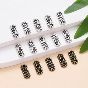 Vue détaillée des perles d'espacement métalliques à trois trous pour la création de bijoux