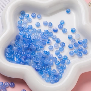 Gros plan de perles d'abaque bleues translucides dans un plateau floral pour bijoux DIY