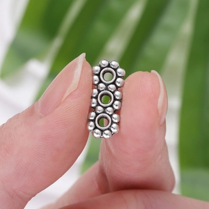 Vue macro d'une perle d'espacement flocon en argent pour bijoux DIY tenue à la main