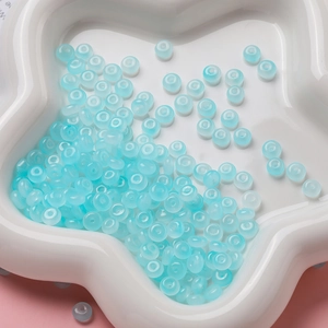 Macro de perles d'abaque bleu clair translucides sur un plateau en céramique blanc