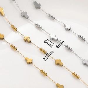 Macro detail of stainless steel cross charms and 2.5mm beads on handmade DIY chains