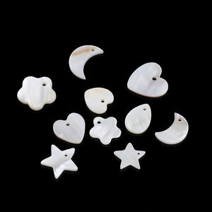 Macro shot of natural iridescent shell charms in star, moon and heart shapes for DIY jewelry