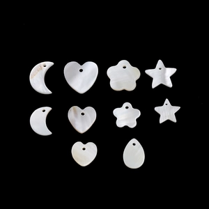Macro detail of various natural shell pendants in moon, star and heart shapes for DIY jewelry
