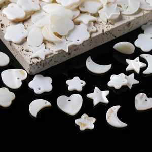 Macro shot of natural shell charms in star and moon shapes on stone and mirror base