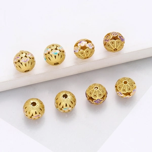 Vue macro de perles creuses dorées avec motifs de nuages de bon augure en émail coloré