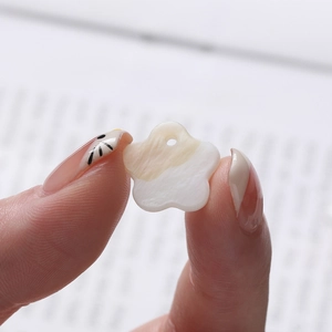 Detailed view of flower-shaped natural shell bead for DIY jewelry with pearl luster