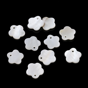 Flat lay of 10 white mother of pearl flower beads with single hole for DIY jewelry