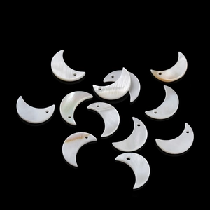 Macro shot of natural mother of pearl moon charms with iridescent luster for DIY jewelry