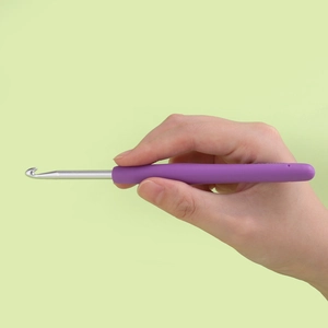 Macro shot of an ergonomic purple TPR handle crochet hook with a silver aluminum head