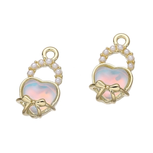 Dettaglio di ciondoli a cuore con gemme barocche iridescenti e fiocchi di perle bianche