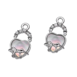 Dettaglio macro del ciondolo a cuore argento con intarsio iridescente e fiocco di strass