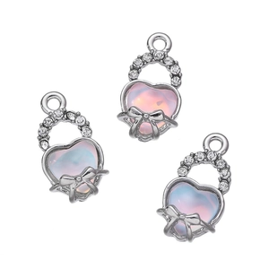 Dettaglio di ciondoli a cuore in argento con gemme iridescenti e fiocchi di cristallo per gioielli