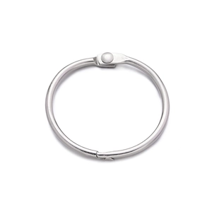 Macro detail of a polished silver binder ring showing secure hinge and interlocking metal closure