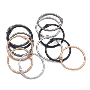 Macro detail of multi-colored hinged metal binder rings in black, silver, and gold finish