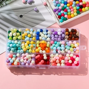 Top view of 15-grid organizer box filled with 6mm matte acrylic beads for DIY crafts