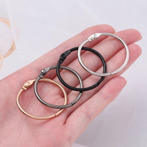 Detail of four colorful metal binder rings held in hand to show size and texture