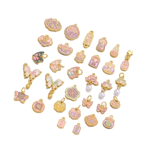 Detailed close-up of pink enamel charms with gold metal butterfly and lotus designs