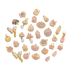 Detail of pink and purple enamel charms with golden butterfly and lotus for DIY jewelry