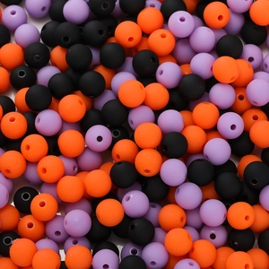 Macro view of matte 6mm acrylic beads in black orange and purple for DIY craft projects