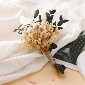 Detailed close-up of a mini dried flower bouquet with white daisies and jute rope wrap