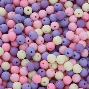 Macro shot of 6mm matte pastel acrylic beads in pink, lavender, and white for DIY jewelry