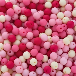 Flat lay of matte texture silicone beads in burgundy, pink and white for DIY crafts