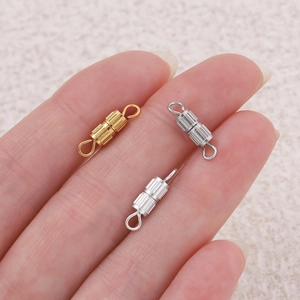 Detailed view of gold and silver spiral screw clasps for DIY necklace making held by hand