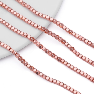 Macro detail of 4mm rose gold hematite cube beads for DIY jewelry making and crafts