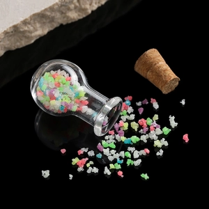 Macro shot of mini clear glass wishing bottles with colorful sand and cork stoppers