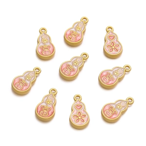 Macro detail of alloy gourd charms with pink enamel and gold-plated Fu characters