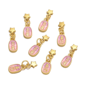 Macro shot of gold star charms with pink enamel and Chinese character engravings