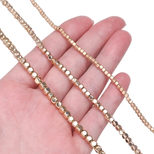 Three sizes of gold hematite square beads strands held to show different diameters