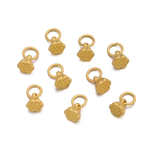 Macro detail of nine matte gold lotus seed pod charms for DIY jewelry making and crafts