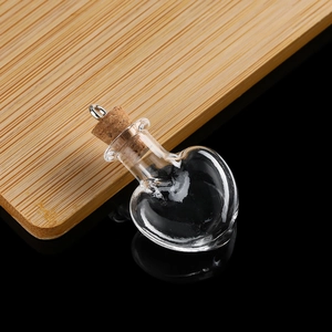 Macro shot of heart-shaped mini glass bottle with cork stopper and metal pendant loop
