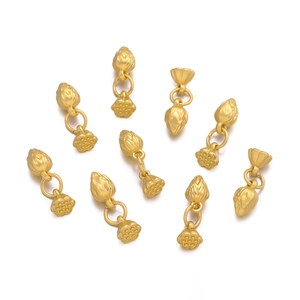 Macro detail of nine golden lotus and seed pod pendants for DIY jewelry making