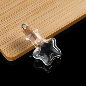 Detailed close-up of a star-shaped mini glass bottle with cork stopper and silver metal ring