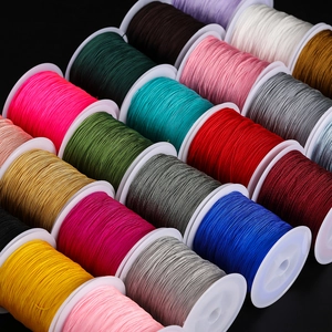 Macro view of 0.4mm colored polyester threads on white bobbins for DIY jewelry weaving