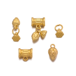 Detail of matte gold lotus seed pod and flower charms for DIY jewelry making