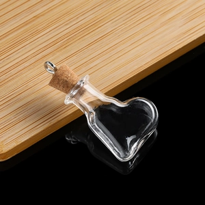 Macro detail of heart-shaped mini glass vial with cork stopper and silver hanging loop