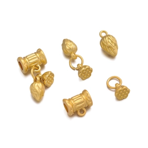 Detail of matte gold lotus seed pod charms and cylinder beads for DIY jewelry making