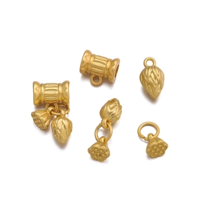 Macro shot of matte gold lotus flower and pod charms for DIY jewelry making