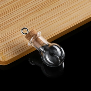Detailed macro view of a mini bulb-shaped clear glass wishing bottle with cork and metal ring