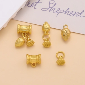 Detailed macro view of matte gold lotus flower pendants and hollow spacer beads for DIY jewelry