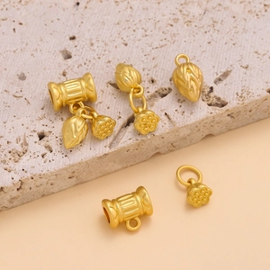Macro detail of golden lotus bud and flower charms with matte metallic texture